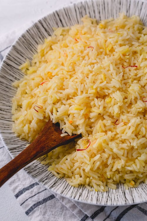 This 5 ingredient saffron rice recipe is an easy way to upgrade a regular rice side dish. Just a pinch of saffron bloomed in hot water and added to toasted rice, magically transforms plain rice into beautiful golden colored rice with delicate floral notes.