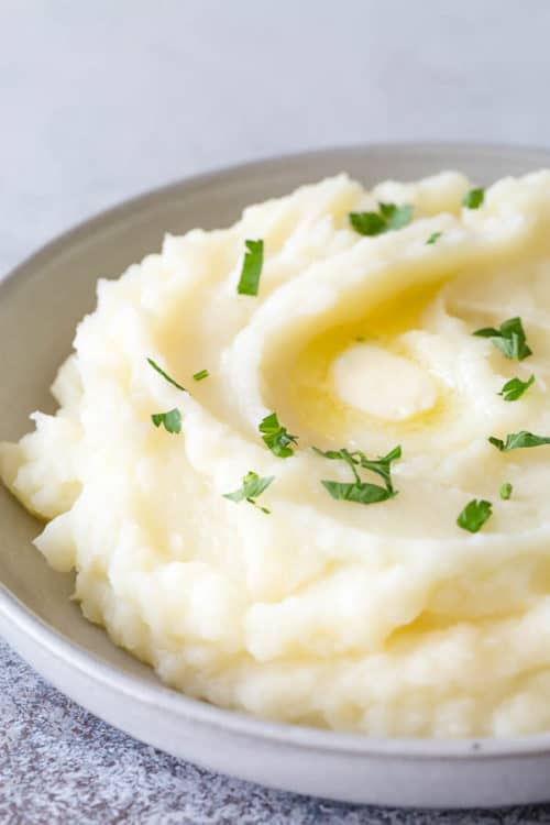 Less than 30 minutes to make the best mashed potatoes in the world (or you could say in your world)! Yes, you read that right. We're making perfectly fluffy Instant Pot Mashed Potatoes with options to customize it to your liking. Read on for my tried and tested tips and tricks for fool-proof fluffy mashed potatoes every time! #mashedpotatoes #InstantPot #InstantPotmashedpotatoes #sidedish #potato