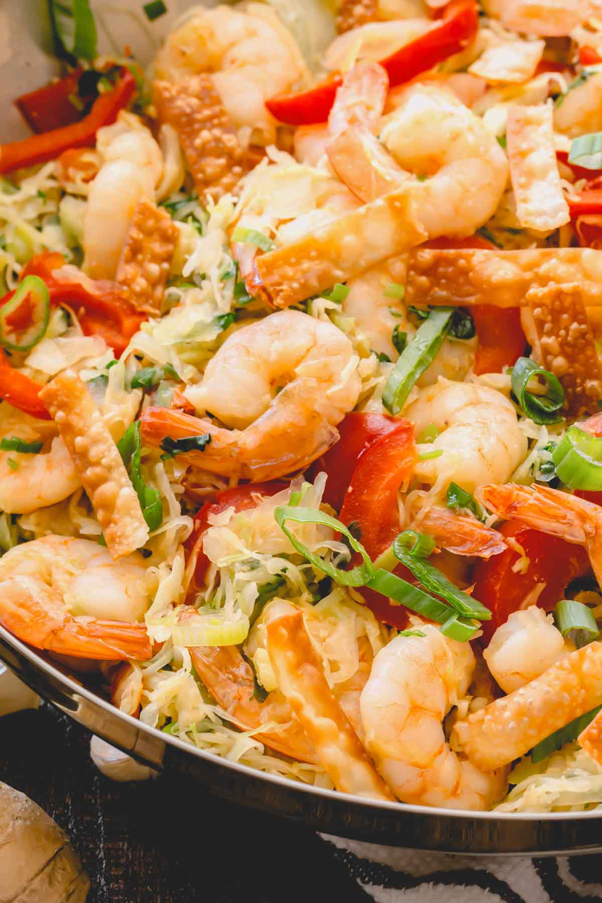 Close up shrimp and cabbage stir fry in a skillet.