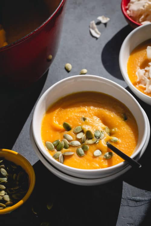 Velvety smooth and creamy, this coconut butternut squash soup is a must on any cold fall day! Subtle hint of ginger, a sprinkle of warm spices and rich coconut milk make this butternut squash so flavorful and cozy! This naturally vegan and healthy, yet hearty soup is ready in less than 45 minutes. #butternutsquashsoup #butternutsquash