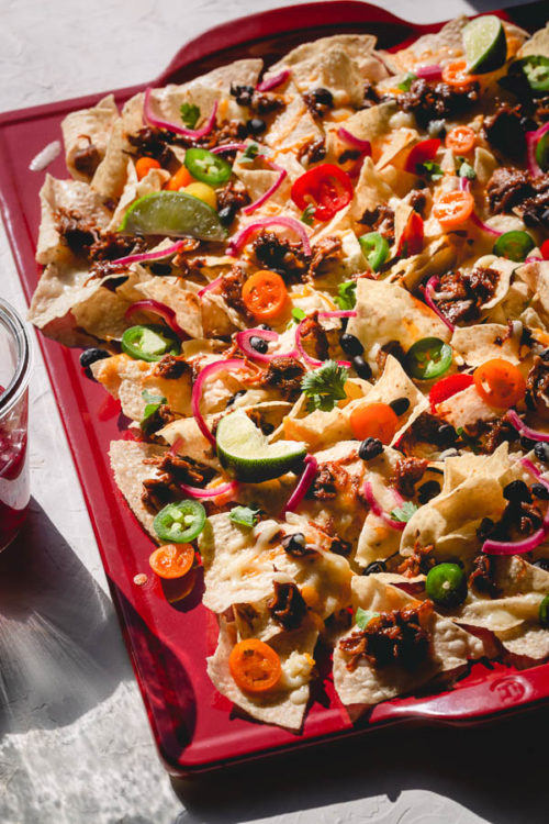 Here's the best nachos recipe around!  Making the best nachos is less about how much ingredients to use, and is more about layering the ingredients properly for the best possible result. #nachos #bestnachos #pulledporknachos