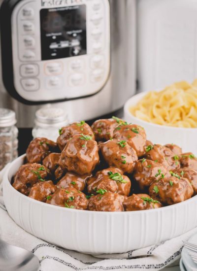 Swedish meatballs in a large serving bowl with Instant Pot in the background.