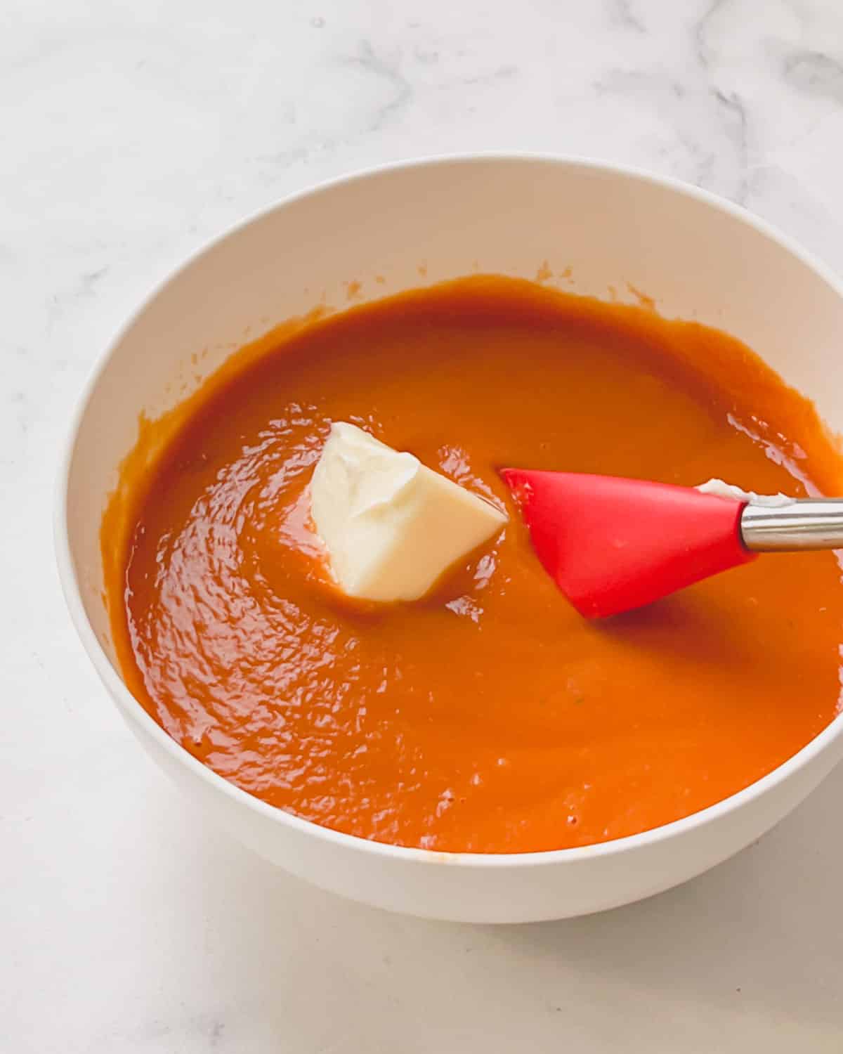 a bowl of tomato sauce with butter in it