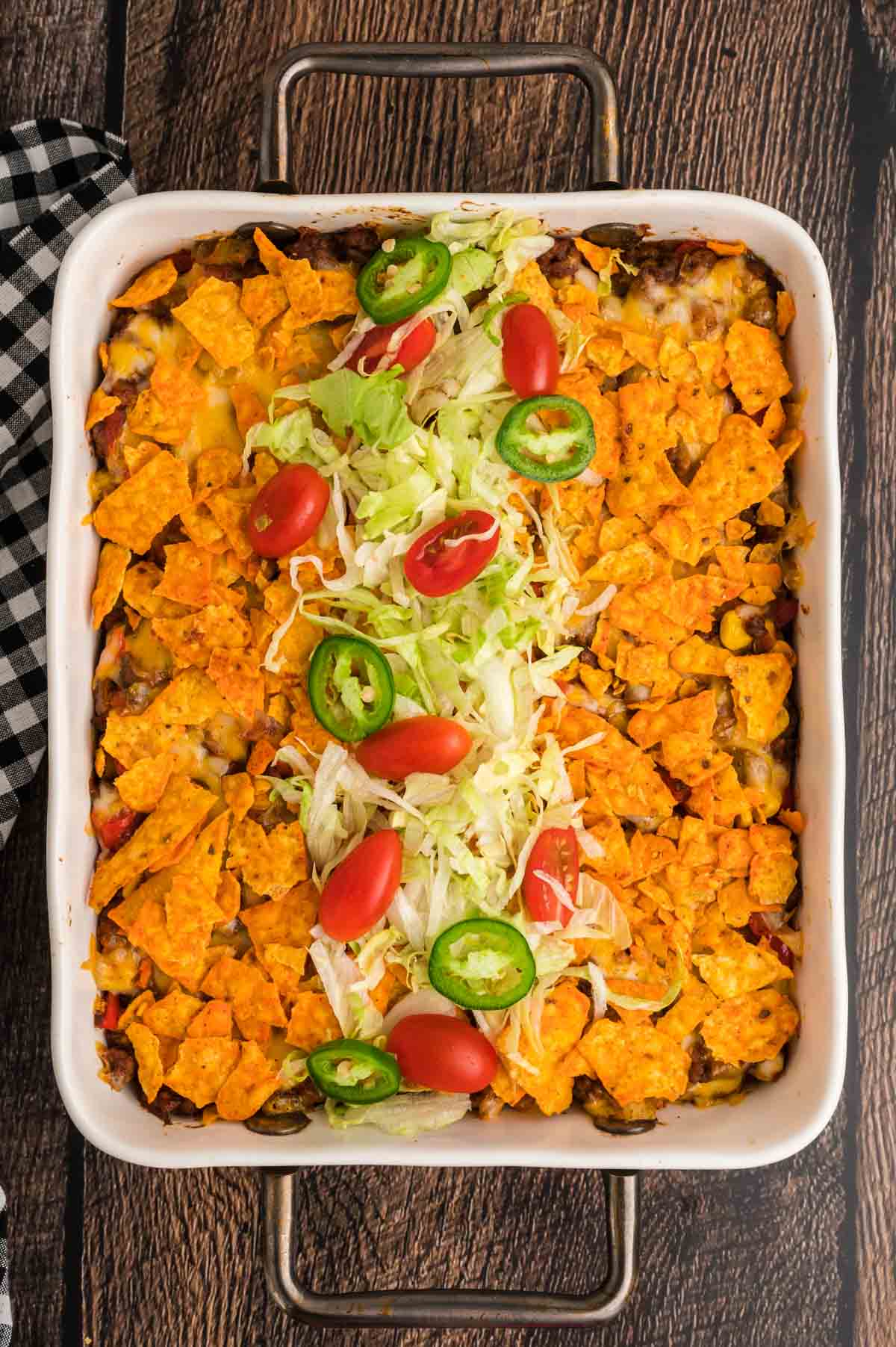 taco casserole with lettuce, tomatoes, and sour cream on top.