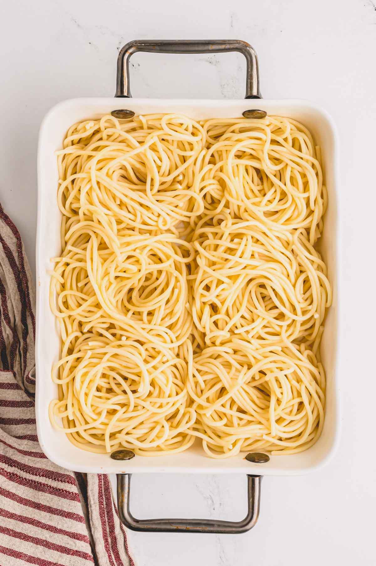 Cooked spaghetti nests in a baking dish.