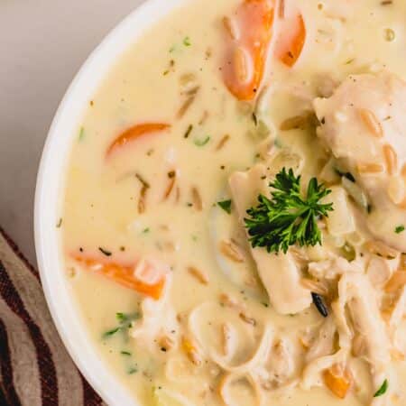 Creamy turkey and wild rice soup in a white bowl.