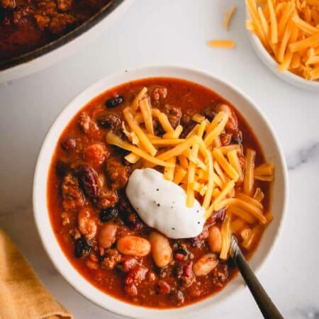 a bowl of chili with cheese and sour cream.