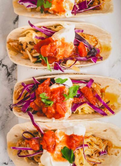 Overhead image of four slow cooker chicken tacos.
